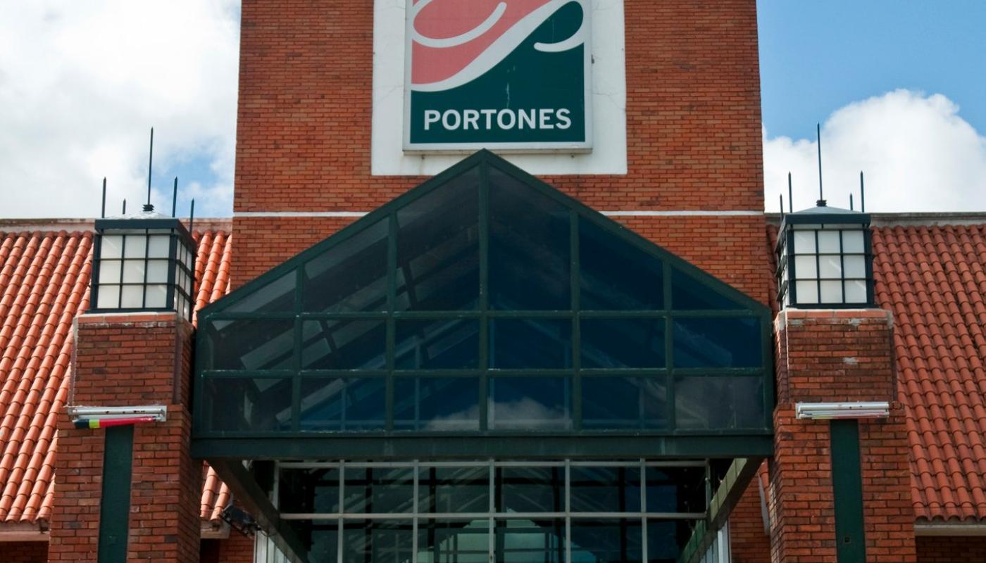 Entrada principal del shopping. Estructura de ladrillos y vidrio de colores. Logo del shopping en el frente. 