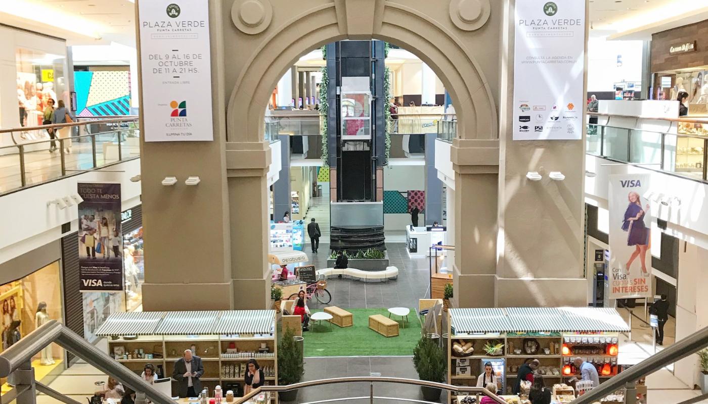 Ingreso al shopping con escalera monumental a dos brazos. Al fondo arco de entrada de la antigua carcel. Diversos negocios en los costados. Vista de los pisos superiores.