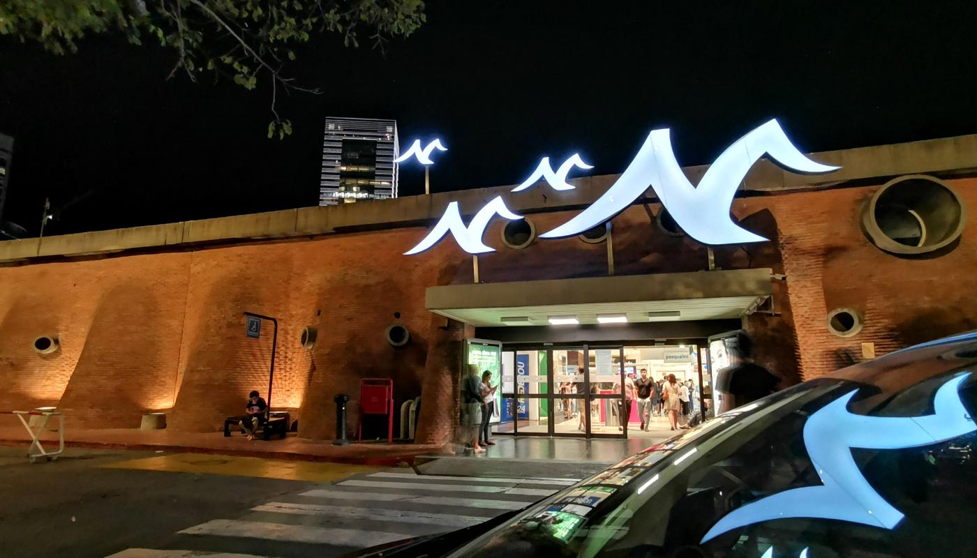 Acceso al montevideo shopping el cual tiene sus características ondulaciones en ladrillo. Se ve el símbolo de la gaviota típico de este shopping.  