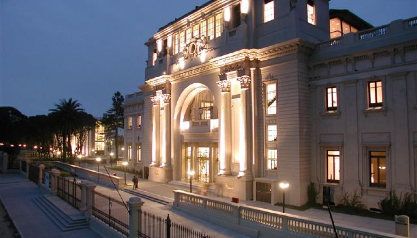 Fachada el edificio principal del Hipódromo de Maroñas. Un edificio antiguo iluminado con luces de diversa intensidad que lo iluminan.  