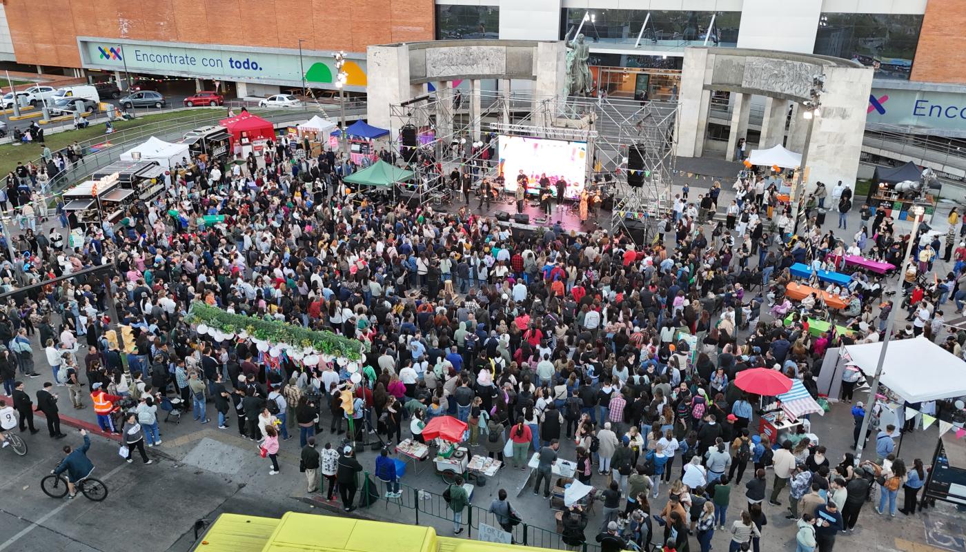 personas alrededor de un escenario de música en la explanada del shopping tres cruces