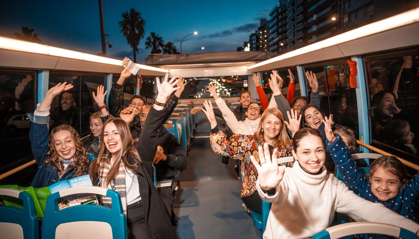 personas saludando en el bus turístico de montevideo
