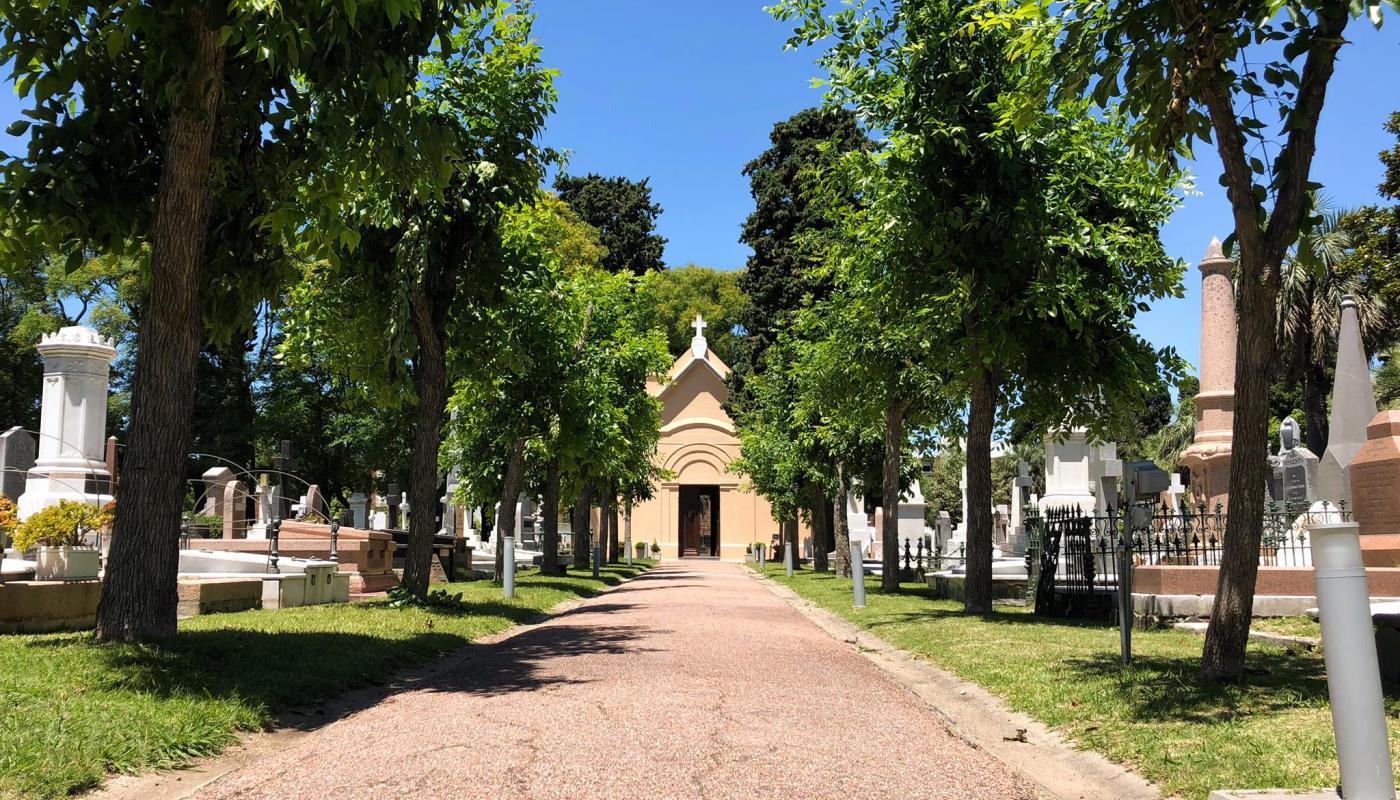 Foto del cementerio: un camino arbolado y al final del mismo la capilla 