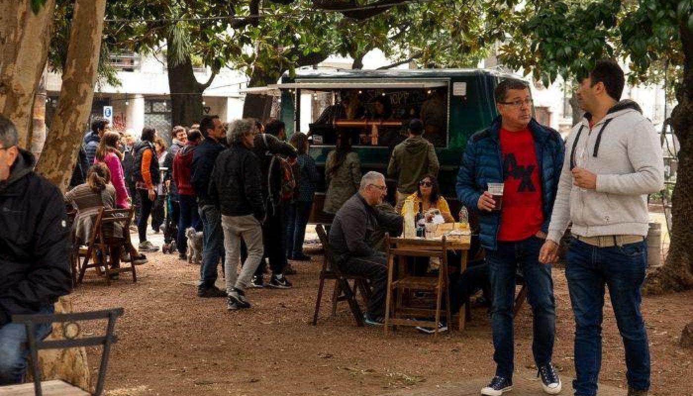 Plaza de ciudad vieja  con mucha gente disfrutándo de feria cultural con musicos , puestos gastronomicos y propuestas artisticas