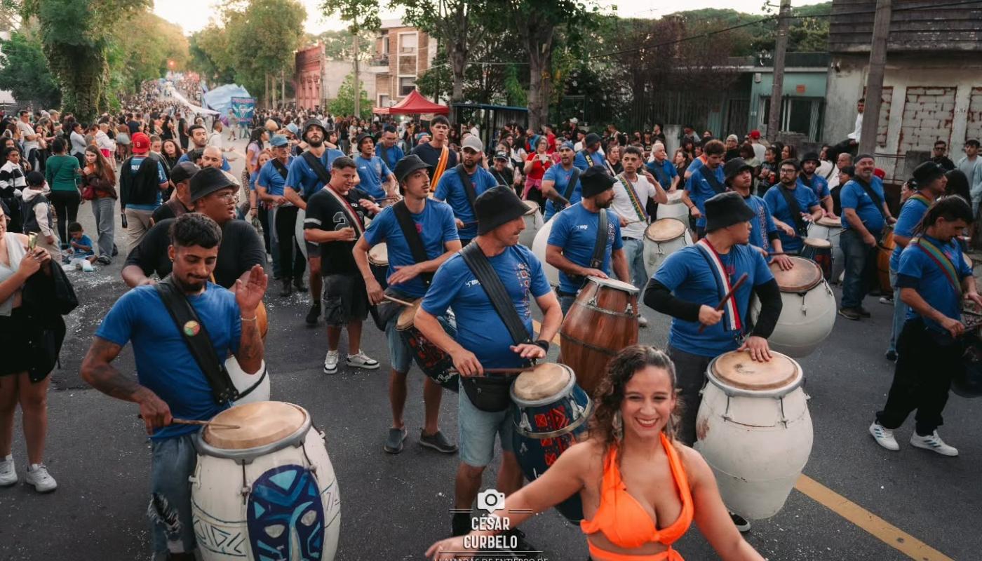 comparsa con vestimenta azul sobre la calle del barrio reus y bailarinas delante de ellos
