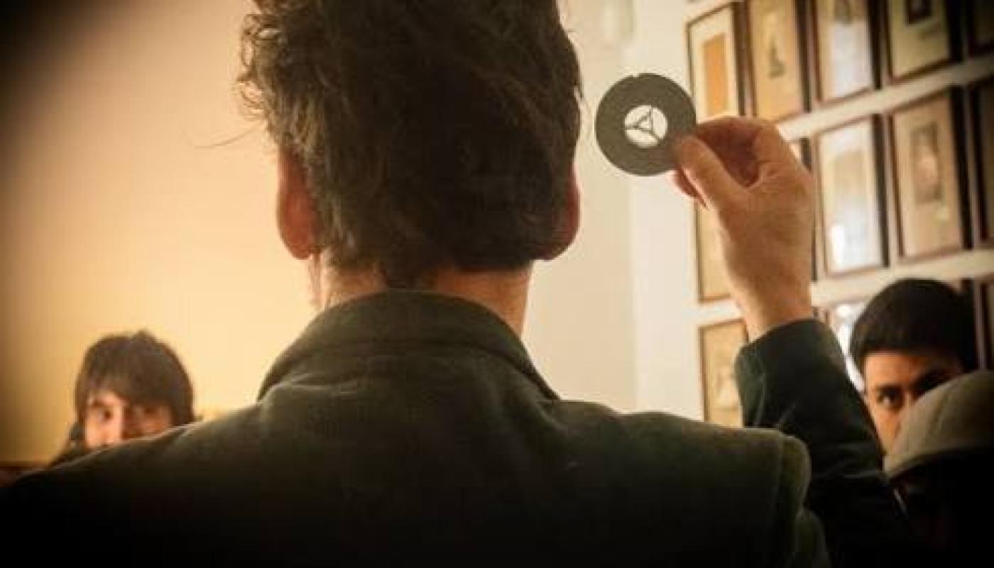 persona de espalda mostrando en un museo a publico de frente objeto fotográfico