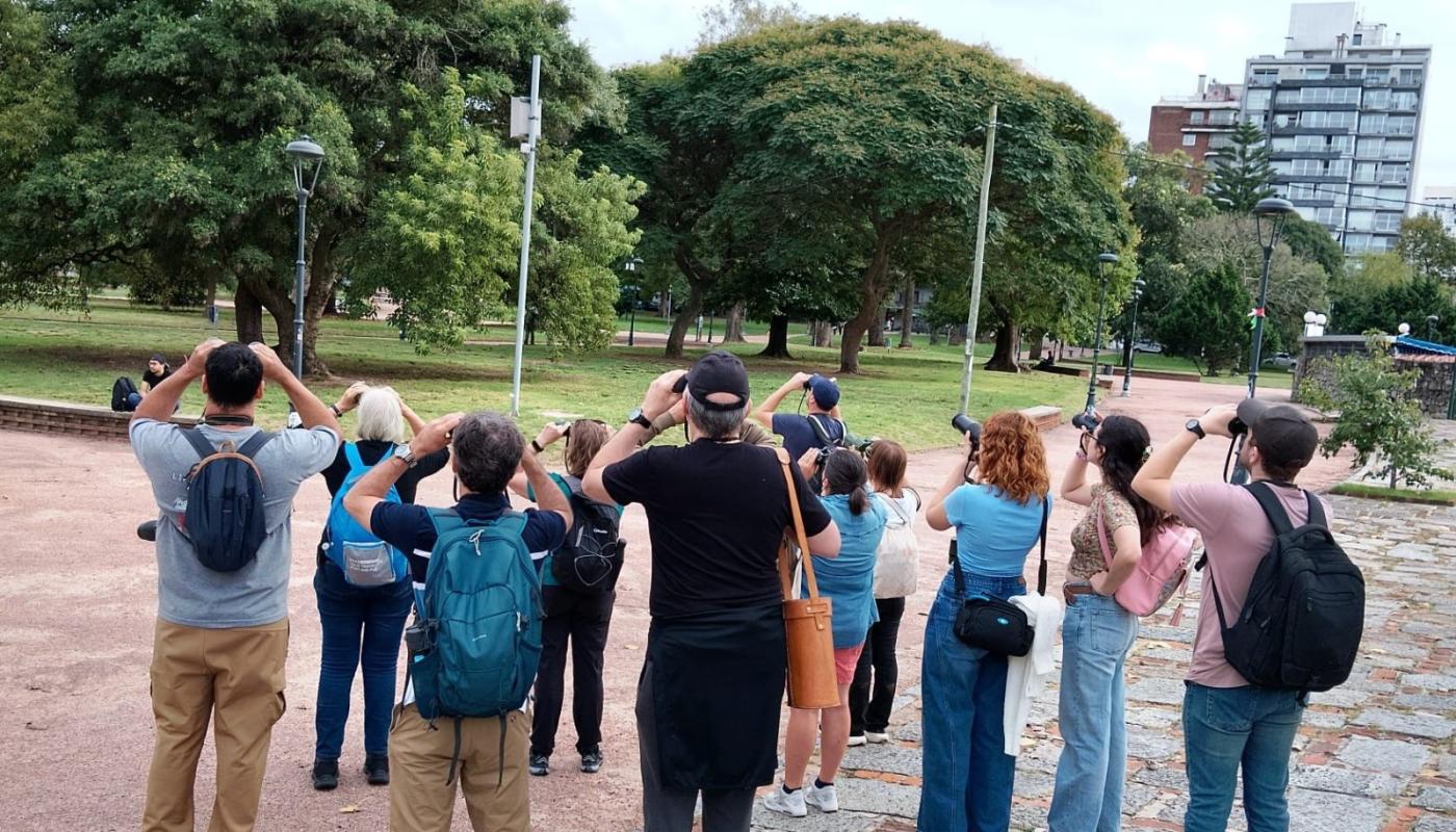grupo de personas con binoculares y camaras de fotos avistando aves