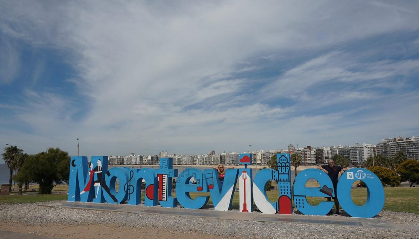 Foto del cartel de Montevideo pintado de celeste y con diferentes dibujos