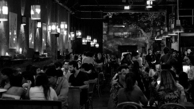 Foto en blanco y negro en la cervecería con mucha gente disfrutando 