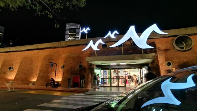 Acceso al montevideo shopping el cual tiene sus características ondulaciones en ladrillo. Se ve el símbolo de la gaviota típico de este shopping.  