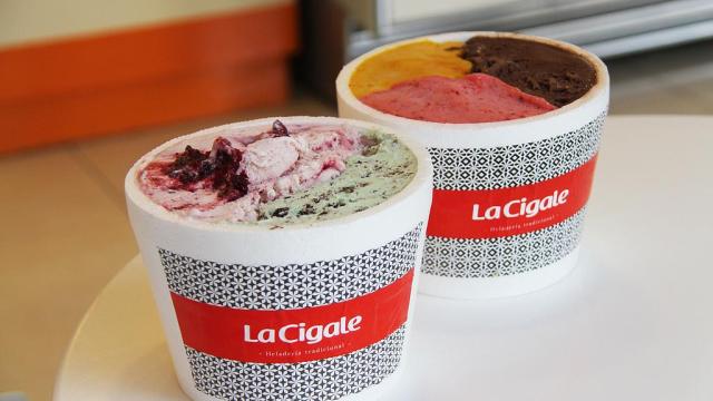 dos vasitos de helados con el logo de la empresa con gustos de helados distintos muy coloridos sobre una mesa