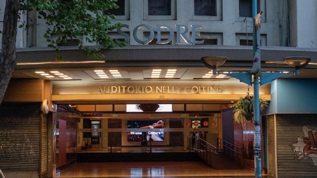 foto a la noche fachada del auditorio desde afuera se asemeja a un templo egipcio. A los lados se ubican dos pilastras acanaladas de influencia art déco