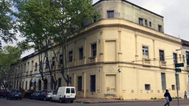 Casona de época de varios pisos en color crema ocupando todo una esquina. 