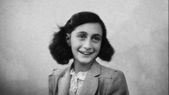 Retrato en blanco y negro de una niña sonriendo, con cabello oscuro peinado con ondas y vestida con chaqueta clara.