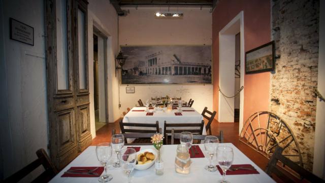 Imagen del comedor con las mesas con manteles elegantes y dispuestas para servir la comida 