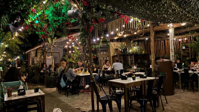 Foto del salón donde se come, mesitas, lucecitas y una pareja cenando