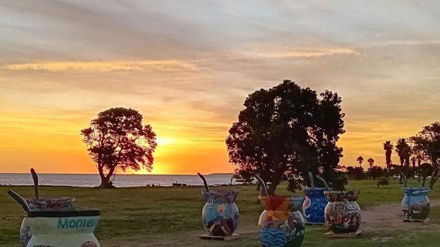 Exposición de mates gigante coloridos en la rambla de montevideo al atardecer