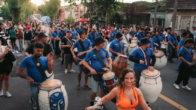 comparsa con vestimenta azul sobre la calle del barrio reus y bailarinas delante de ellos