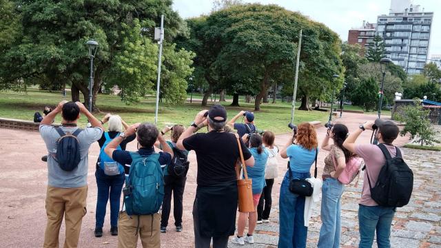 grupo de personas con binoculares y camaras de fotos avistando aves