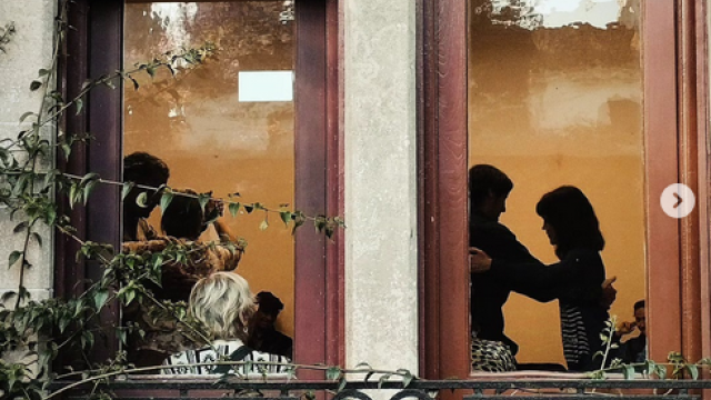 siluetas de personas bailando tango através de dos centans de maderadeeespacio cultural