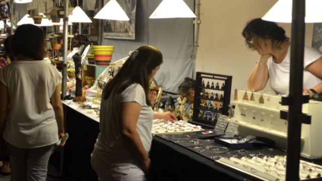Foto de una persona comprando en un puestito de la feria