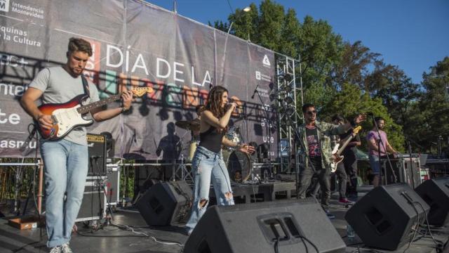 escenario con una banda joven y jovenes disfrutando de un espectaculo
