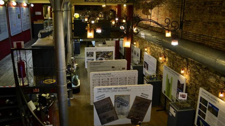 La foto refleja la sala principal del museo, su iluminación a través de focos así como paneles ilustrativos con imagenes y texto de la tragedía de los Andes 