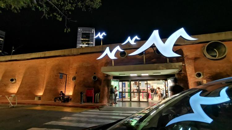 Acceso al montevideo shopping el cual tiene sus características ondulaciones en ladrillo. Se ve el símbolo de la gaviota típico de este shopping.  