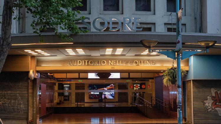 foto a la noche fachada del auditorio desde afuera se asemeja a un templo egipcio. A los lados se ubican dos pilastras acanaladas de influencia art déco