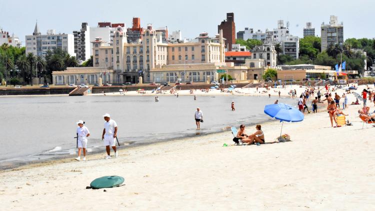 playa ramirez en epoca estival con gente en la arena y en el agua y de fondo los edificios que la rodean como el edificio Mercosur 